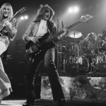 Alex Lifeson (left) and Geddy Lee (with Neil Peart on drums) on stage in 1976 on the tour that followed the release of 2112</em