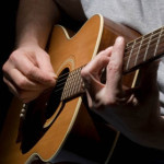Closeup of guitar and muscian's hands.
